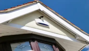 Home intruder alarm system on outside of house.