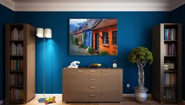large screen tv on wall surrounded by bookshelves.