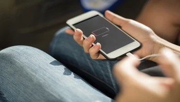 Charging smart phone with cord.