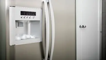 Water maker on the front of a stainless steel refrigerator.